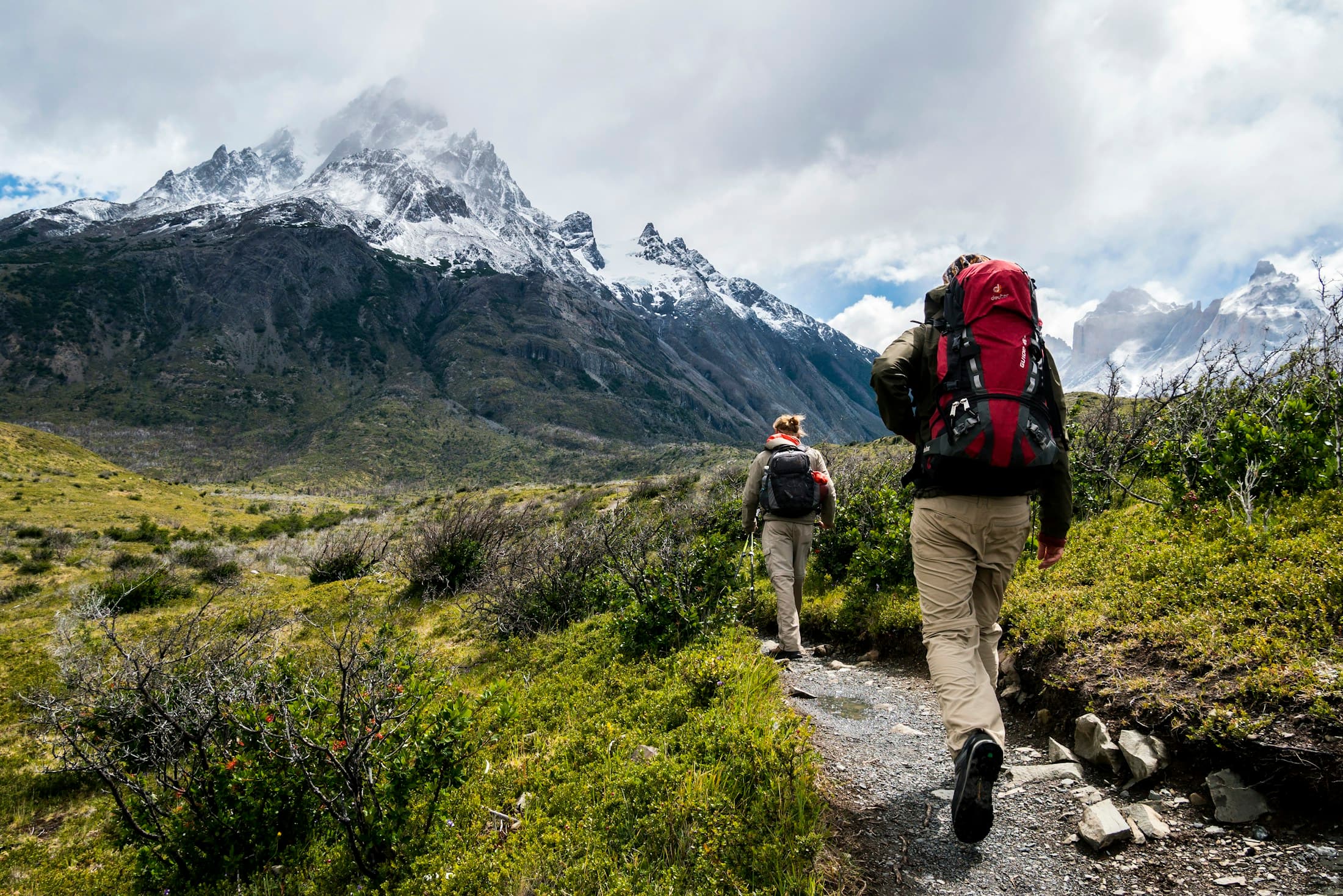 A group of hikers making their way up a sunlit mountain trail
